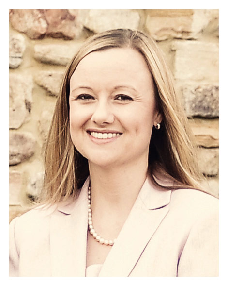 A woman in a pink jacket smiling for the camera.