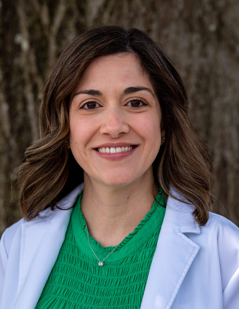 A woman in green shirt and white coat.