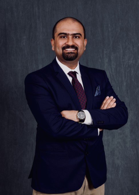 A man in a suit and tie with his arms crossed.